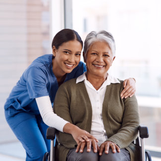 aide and senior woman smiling together