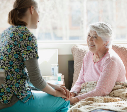 aide and senior woman smiling at each other