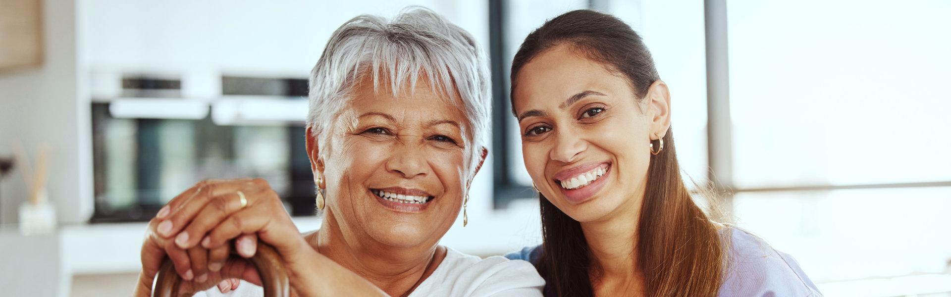 aide and senior woman smiling together