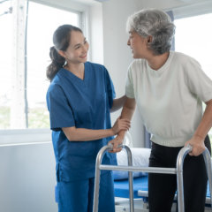 aide and senior woman smiling at each other