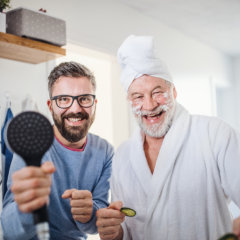 aide and senior man smiling at the bathroom