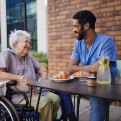 aide and senior woman smiling at each other