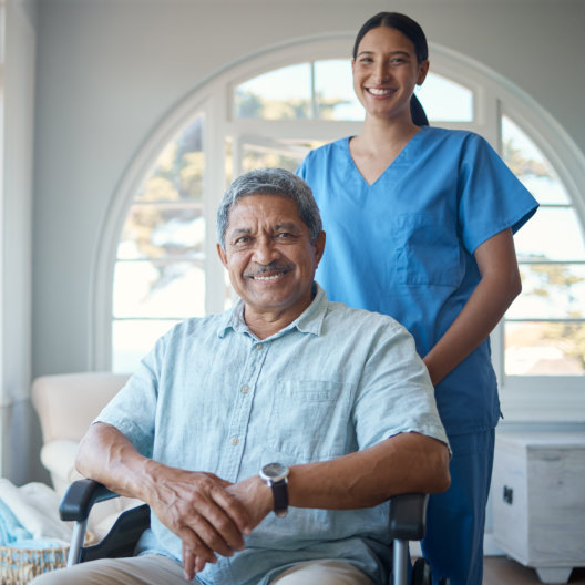 aide and senior man smiling