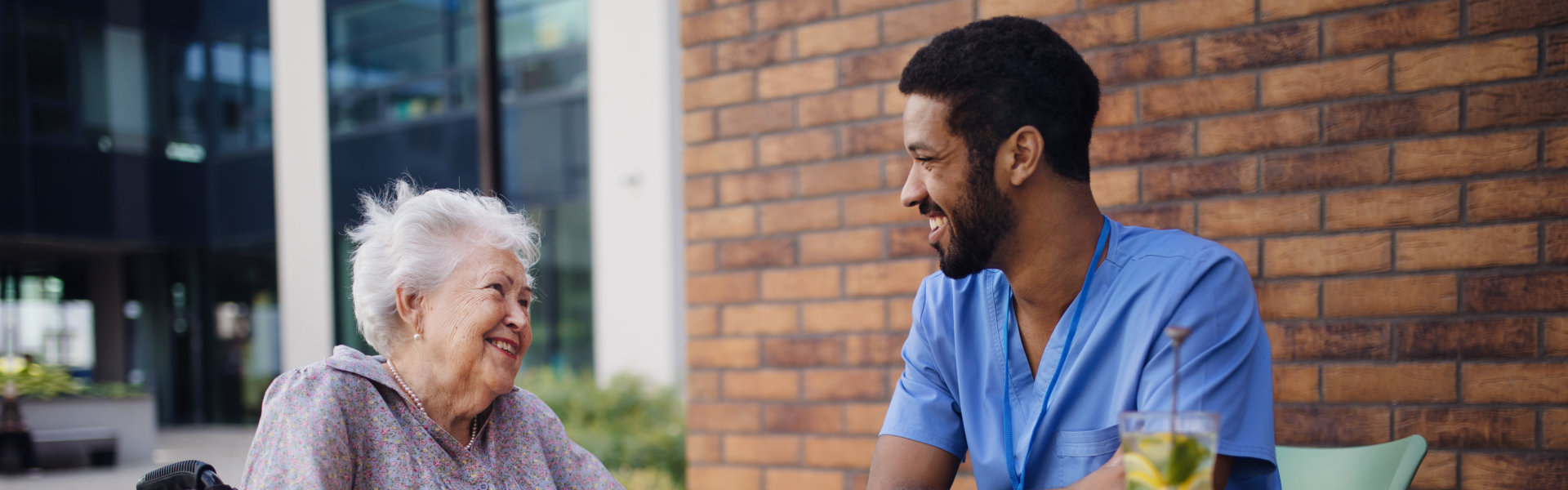 aide and senior woman smiling at each other