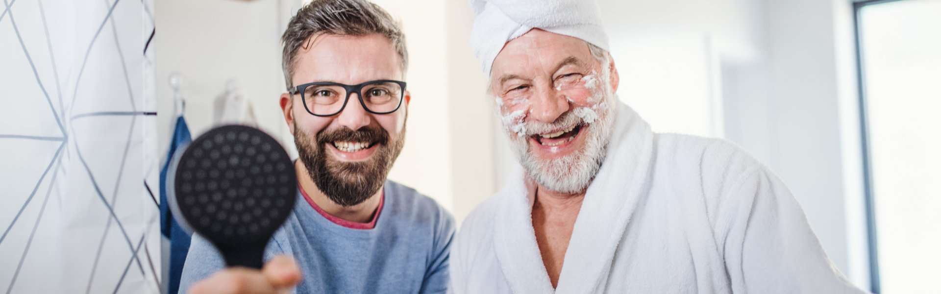aide and senior man smiling at the bathroom